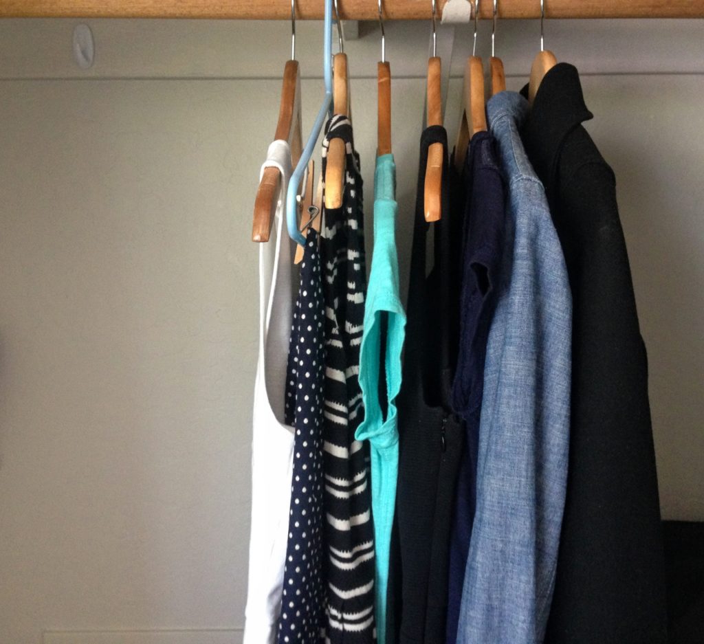 minimalist ethical capsule wardrobe hanging in closet, image